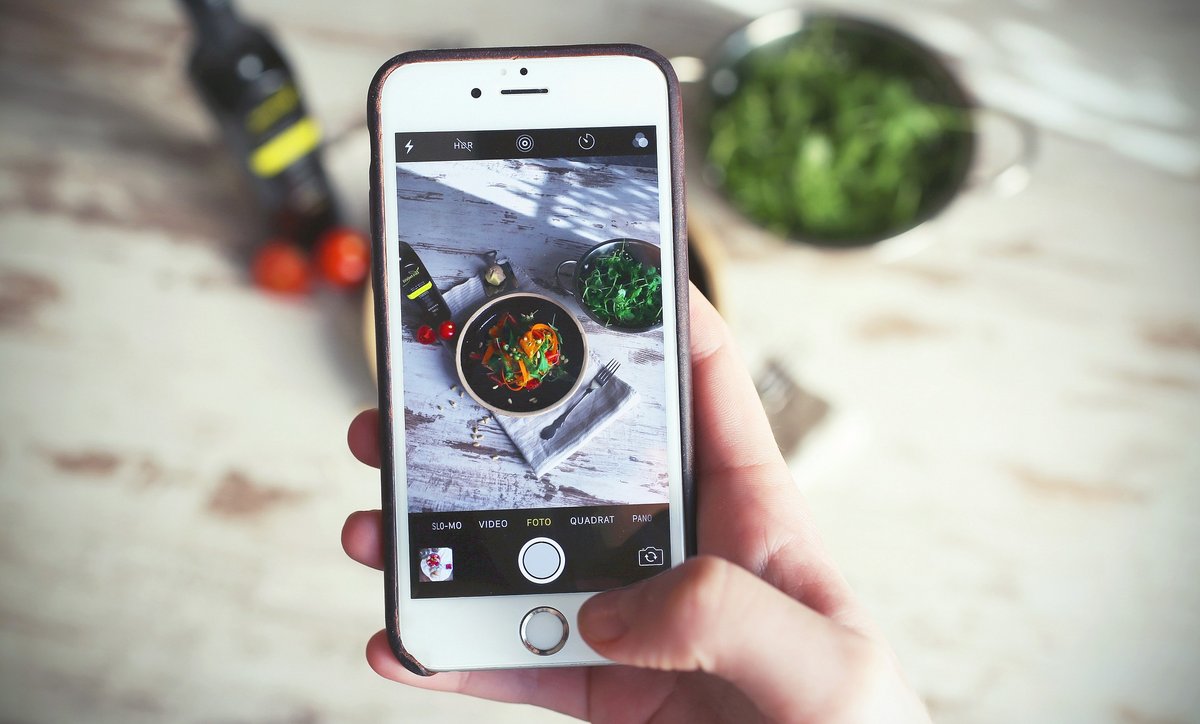 Mit dem Smartphone wird ein Bild einer Mahlzeit aufgenommen.