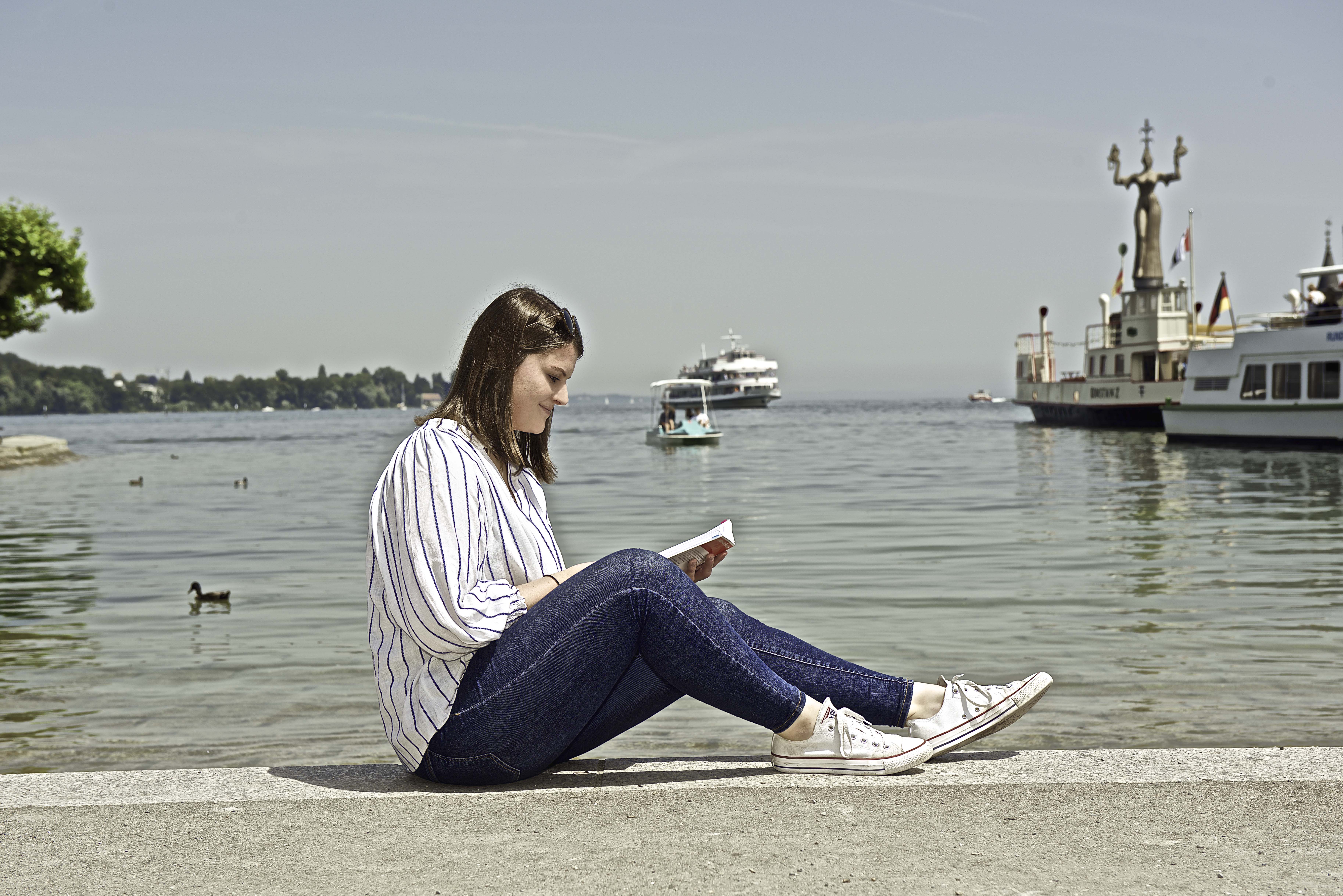 Lesende Studentin am Seeufer