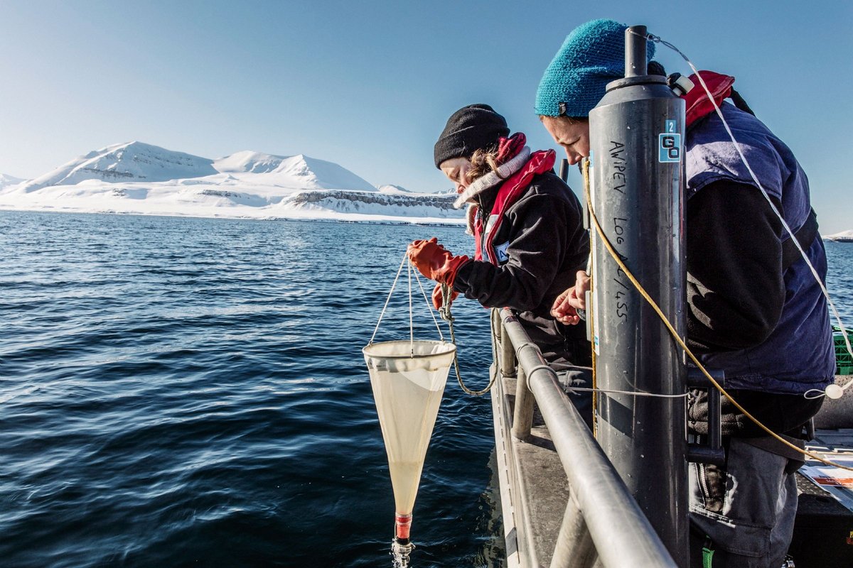 Zwei Wissenschaftlerinnen auf einem Boot auf einem Fjord. 