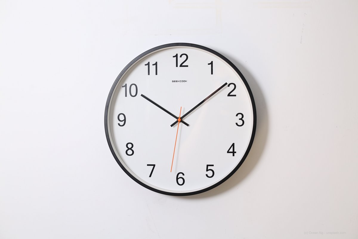 Eine runde Wanduhr zeigt die Uhrzeit 10.08 Uhr an