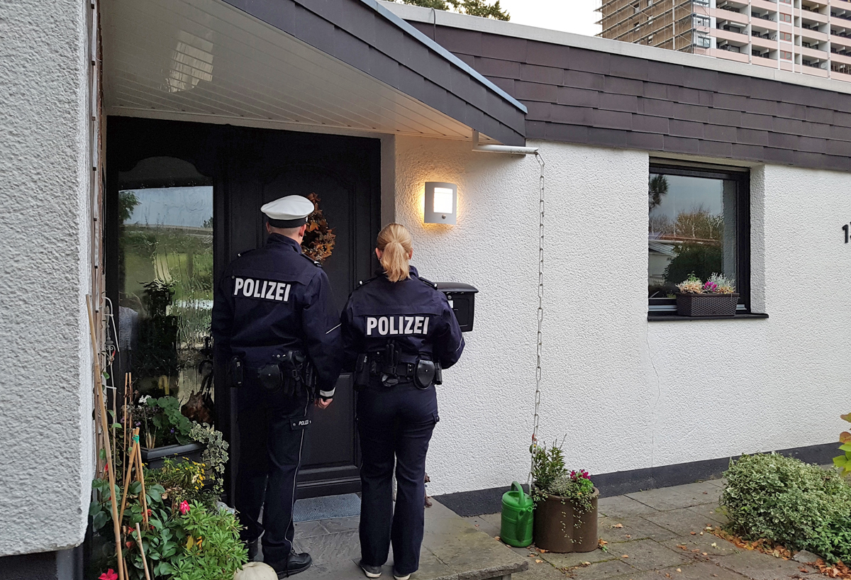 Zwei Polizisten stehen vor einer Haustür. Copyright:  Manuel Plewnia