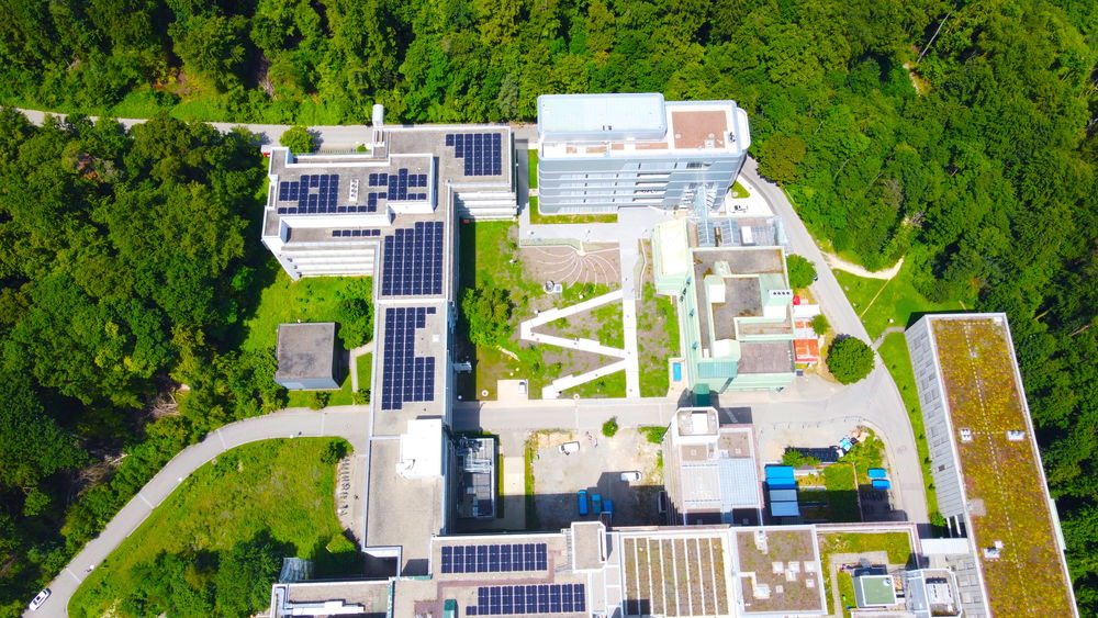 Luftaufnahme zeigt Dächer der Universität Konstanz mit Photovoltaikanlagenl