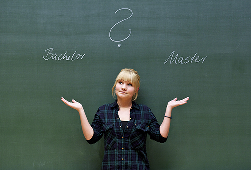 Student stands in front of blackboard and thinks about Bachelor's or Master's degree programme